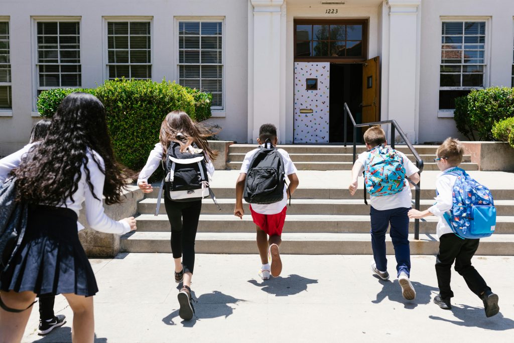 Children running toward a school because they have a bright future.