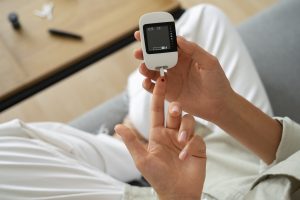 woman using a glucose meter to check diabetes