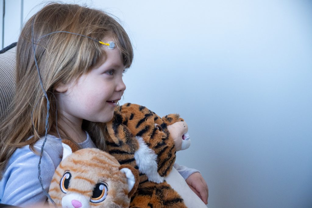 Happy, calm girl holding stuffed animals as she received neurofeedback from Integrative Mind and Body Services in Northeastern PA